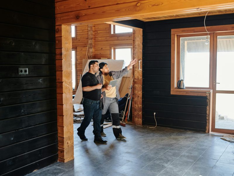 pexels-photo-8961300-8961300 Two adults discussing home renovation in a partially constructed modern wooden interior.